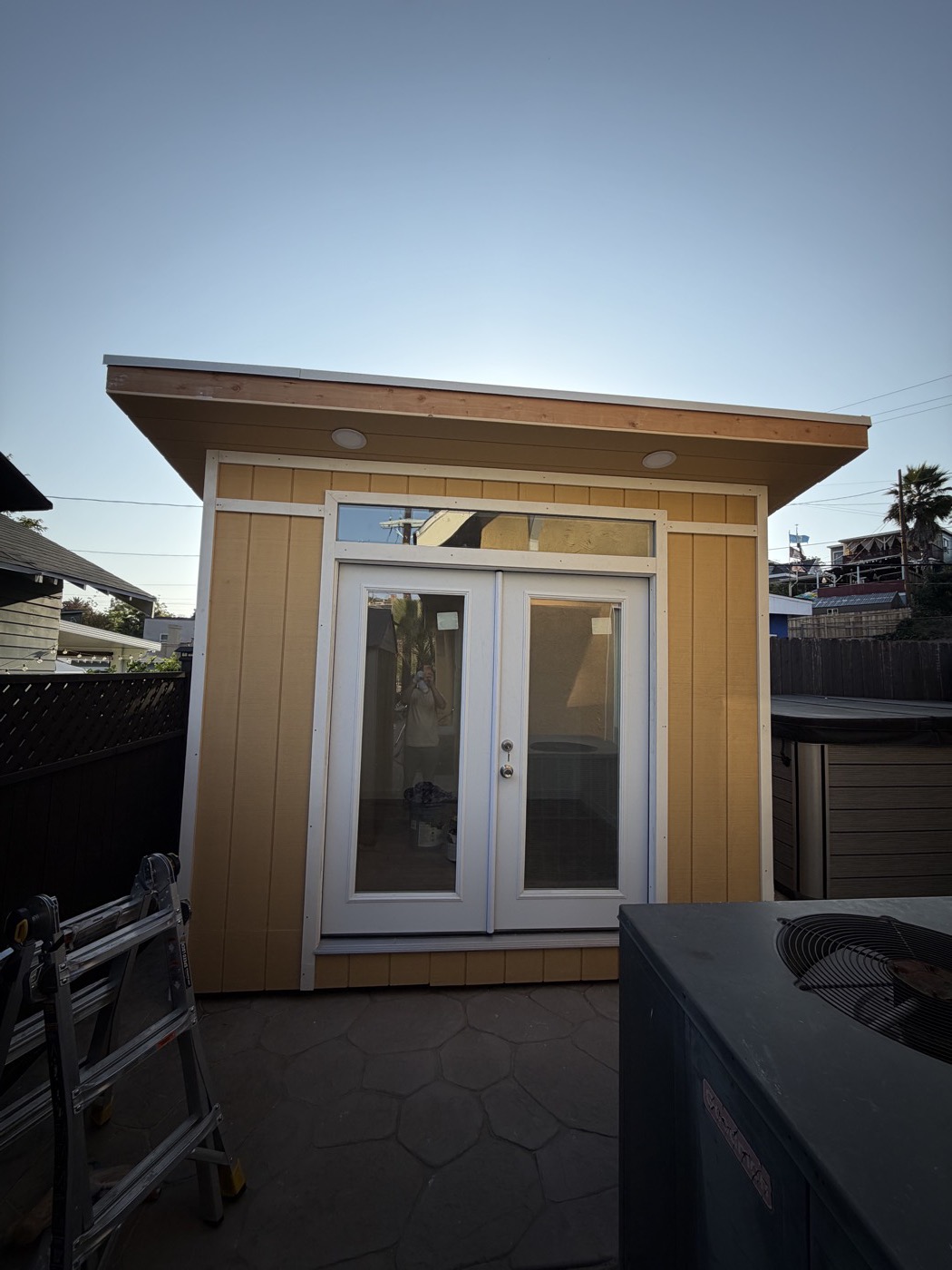 Yellow 10 by 10 ft home gym studio with white french doors and transom window